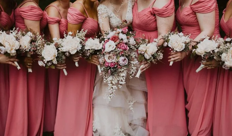 Close shot of a bride with her bridesmaids holding flowers robe demoiselle d'honneur terracotta